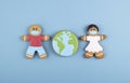 two gingerbread man medics in a mask girl and boy, gingerbread planet earth in the middle Royalty Free Stock Photo