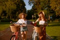 Two girl best friends nice conversation while walking with bicycle at park Royalty Free Stock Photo