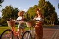 Two girl best friends nice conversation while walking with bicycle at park Royalty Free Stock Photo