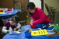 Two girl children are drawing and making some craft work