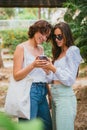 Two girl friends are looking at a smart phone