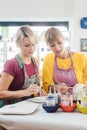 Two girl friends painting their own handmade ceramics