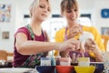 Two girl friends painting their own handmade ceramics