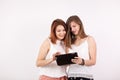 Two girl friends smiling and looking at a tablet PC Royalty Free Stock Photo