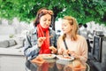 friends students trying sausage with grimace of disgust on their face. The concept of spoiled fast food Royalty Free Stock Photo