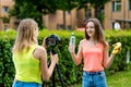 Two girl friends. Summer in nature. Record video on camera. The concept of young bloggers. Healthy eating. Emotions are