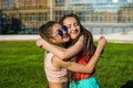 Two girl friends with zizi cornrows dreadlocks hugging each other