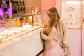 Two girlfriends in a cafe by the window with a cake. Girlfriend in a store