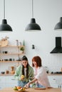 Two girlfriends cut fruit in the kitchen Royalty Free Stock Photo