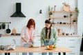 Two girlfriends cut fruit in the kitchen Royalty Free Stock Photo