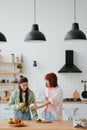 Two girlfriends cut fruit in the kitchen Royalty Free Stock Photo