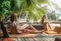 Two girlfriends enjoying tropical vacation sitting in bamboo beach bar Royalty Free Stock Photo