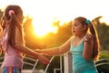 Two girlfriends girls talking on the street at sunset. Schoolgirls , two girls on vacation Royalty Free Stock Photo