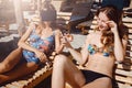 Two girlfriends having fun with VR glasses and smartphone on beach