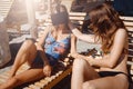 Two girlfriends having fun with VR glasses and smartphone on beach