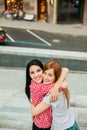 Two girlfriends hugging in the street