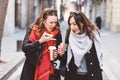 Two girlfriends looking into a coffee cup with shocked faces