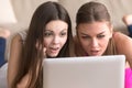 Two girlfriends looking at laptop screen with expression of exci Royalty Free Stock Photo