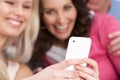 Two Girlfriends Looking At Pictures On Smartphone Royalty Free Stock Photo