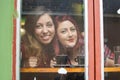 Two girlfriends looking through the window