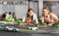 Two girlfriends control remote models of race cars