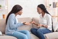 Two girlfriends sitting on sofa and arguing with each other Royalty Free Stock Photo