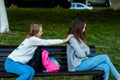 Two girlfriends in summer on the bench. Offended each other. Friends quarreled. Nigativa among girls. The problem is in Royalty Free Stock Photo