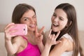 Two young happy girlfriends taking selfie with smartphone. Royalty Free Stock Photo