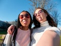 two beautiful young girls making funny faces  wearing sunglasses and casual clothes  outdoors Royalty Free Stock Photo