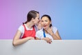 Two girls in aprons pose with a white Billboard. advertising concept