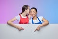 Two girls in aprons pose with a white Billboard. advertising concept