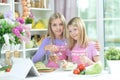 Two girls in aprons preparing fresh salad