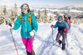 two girls with backpacks walk along a path in the winter mountains. hiking in the mountains Royalty Free Stock Photo