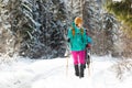 two girls with backpacks walk along a path in the winter mountains. hiking in the mountains Royalty Free Stock Photo