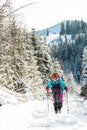 two girls with backpacks walk along a path in the winter mountains. hiking in the mountains Royalty Free Stock Photo