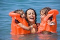 Two girls bathing in lifejackets with young woman