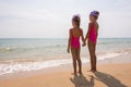 Two girls in bathing suits standing on beach and look at the horizon Royalty Free Stock Photo