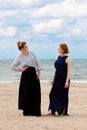 Two girls beach sand sea talking, De Panne, Belgium Royalty Free Stock Photo