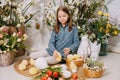 Two girls in a beautiful Easter photo zone with flowers, eggs, chickens and Easter bunnies. Happy Easter holiday. Royalty Free Stock Photo