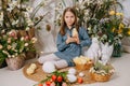 Two girls in a beautiful Easter photo zone with flowers, eggs, chickens and Easter bunnies. Happy Easter holiday. Royalty Free Stock Photo