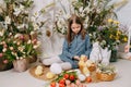 Two girls in a beautiful Easter photo zone with flowers, eggs, chickens and Easter bunnies. Happy Easter holiday. Royalty Free Stock Photo