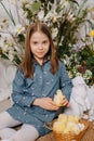 Two girls in a beautiful Easter photo zone with flowers, eggs, chickens and Easter bunnies. Happy Easter holiday. Royalty Free Stock Photo