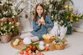 Two girls in a beautiful Easter photo zone with flowers, eggs, chickens and Easter bunnies. Happy Easter holiday. Royalty Free Stock Photo