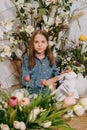 Two girls in a beautiful Easter photo zone with flowers, eggs, chickens and Easter bunnies. Happy Easter holiday. Royalty Free Stock Photo