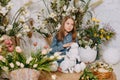 Two girls in a beautiful Easter photo zone with flowers, eggs, chickens and Easter bunnies. Happy Easter holiday. Royalty Free Stock Photo