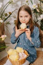 Two girls in a beautiful Easter photo zone with flowers, eggs, chickens and Easter bunnies. Happy Easter holiday. Royalty Free Stock Photo