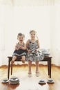 Two girls on bench with dishes