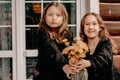 Two girls in black dresses hold flowers in their hands and smile at each other. Royalty Free Stock Photo