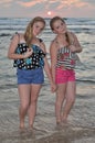 Two girls blonde on the beach at sunset