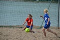 Beach football, girls playing in team outfits on the sand beach